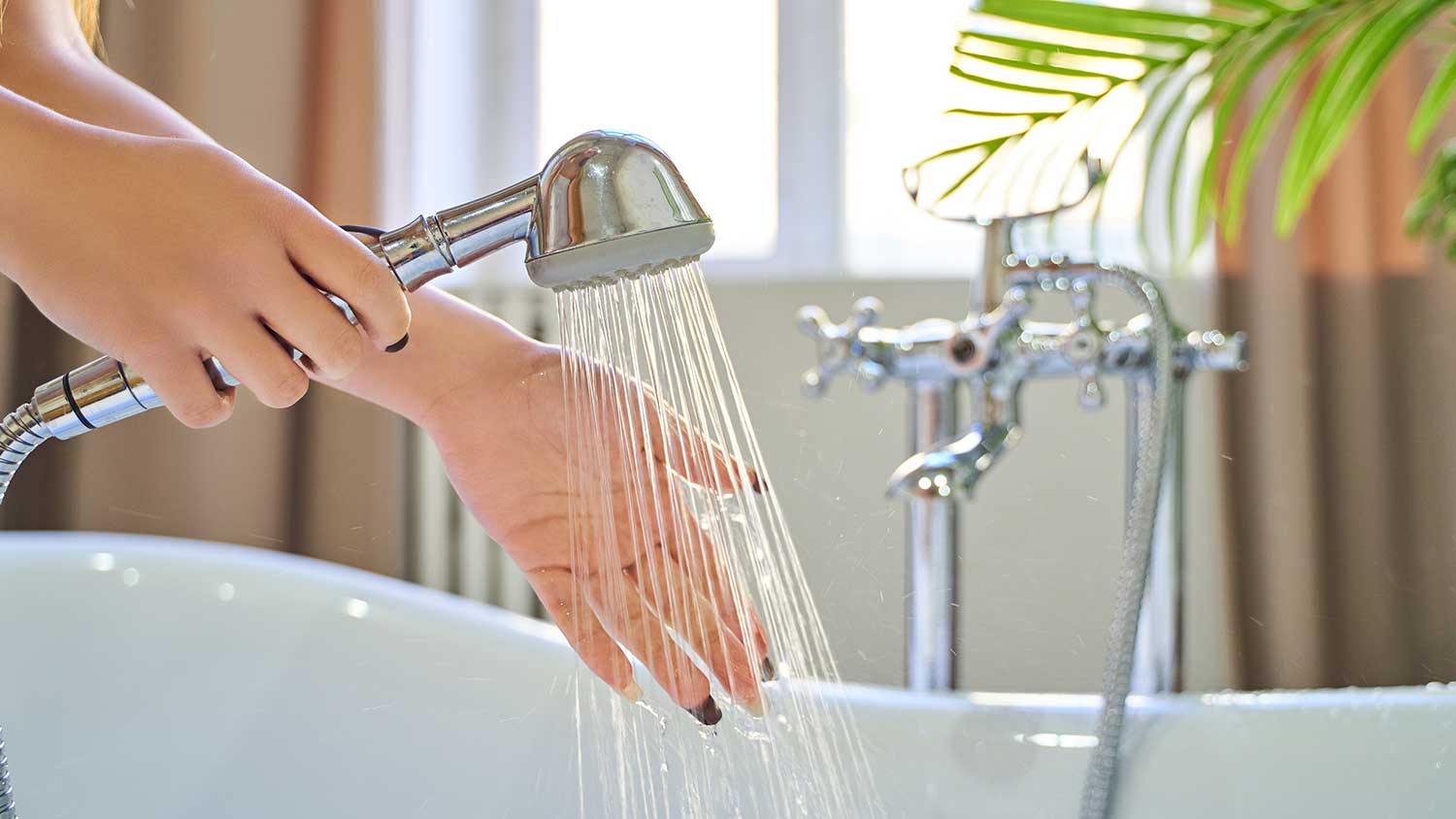 Woman testing water temperature with her hand