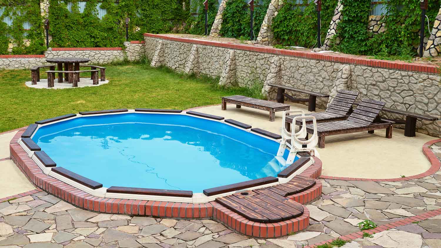 A plunge pool with wooden furniture around it