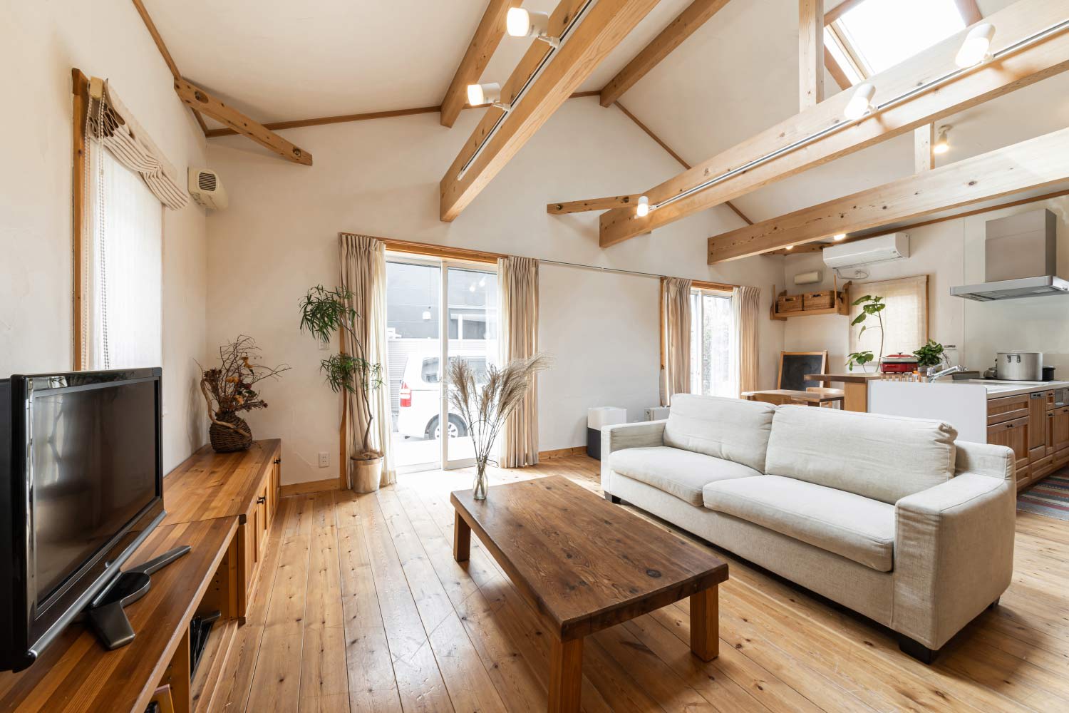 living room with exposed wood beams and skylights