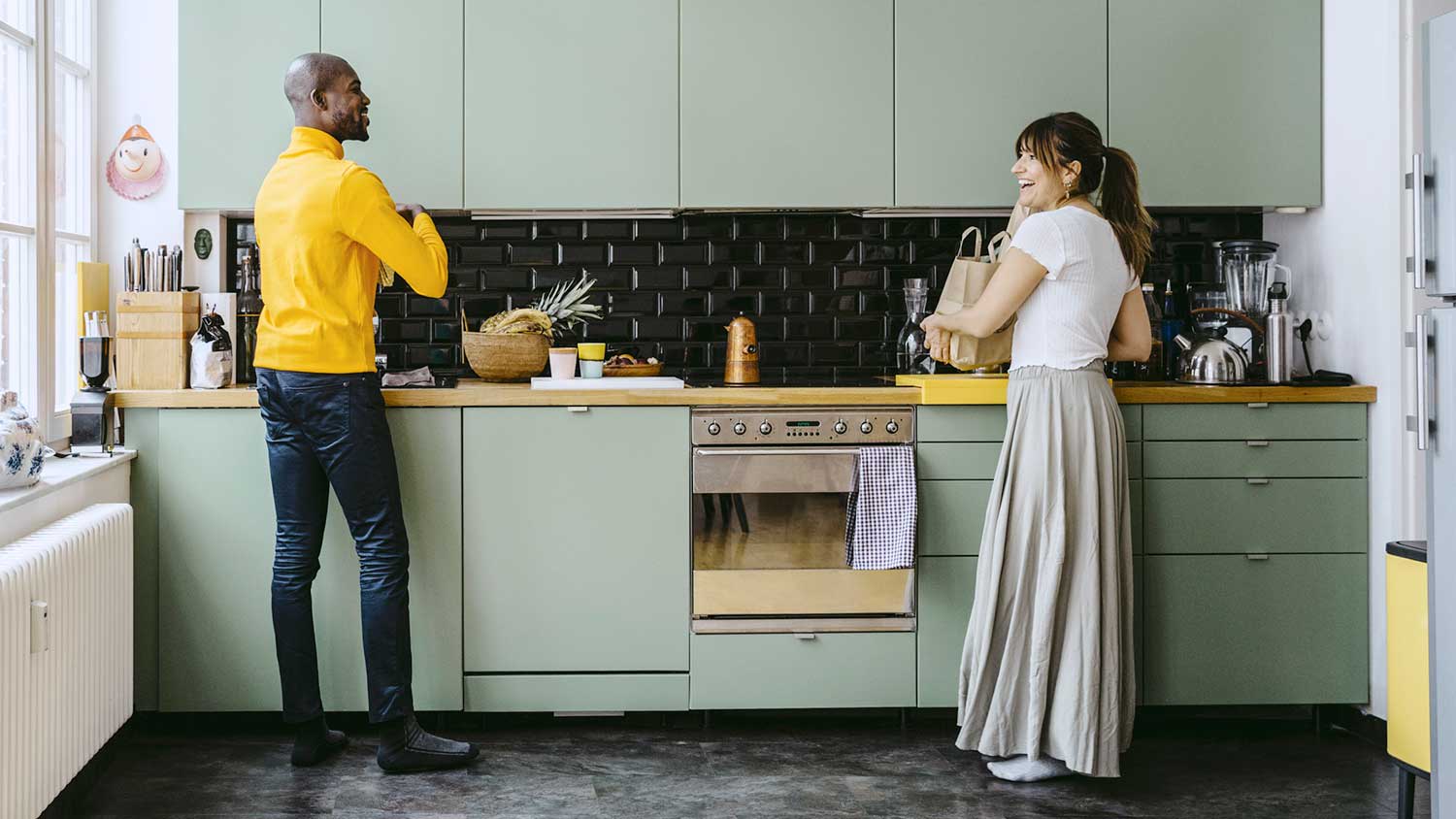 Happy couple doing chores in the kitchen