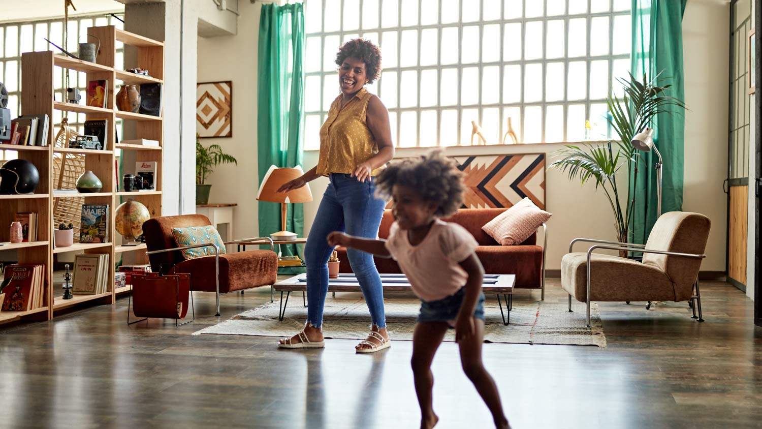 mother and daughter playing in modern living room with space