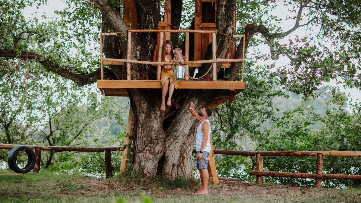 family sitting in treehouse