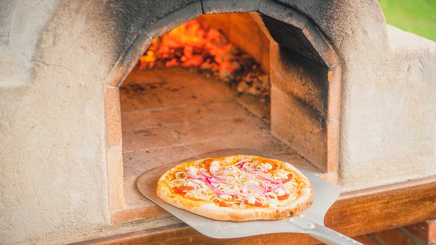 Baking pizza in an outdoor pizza oven