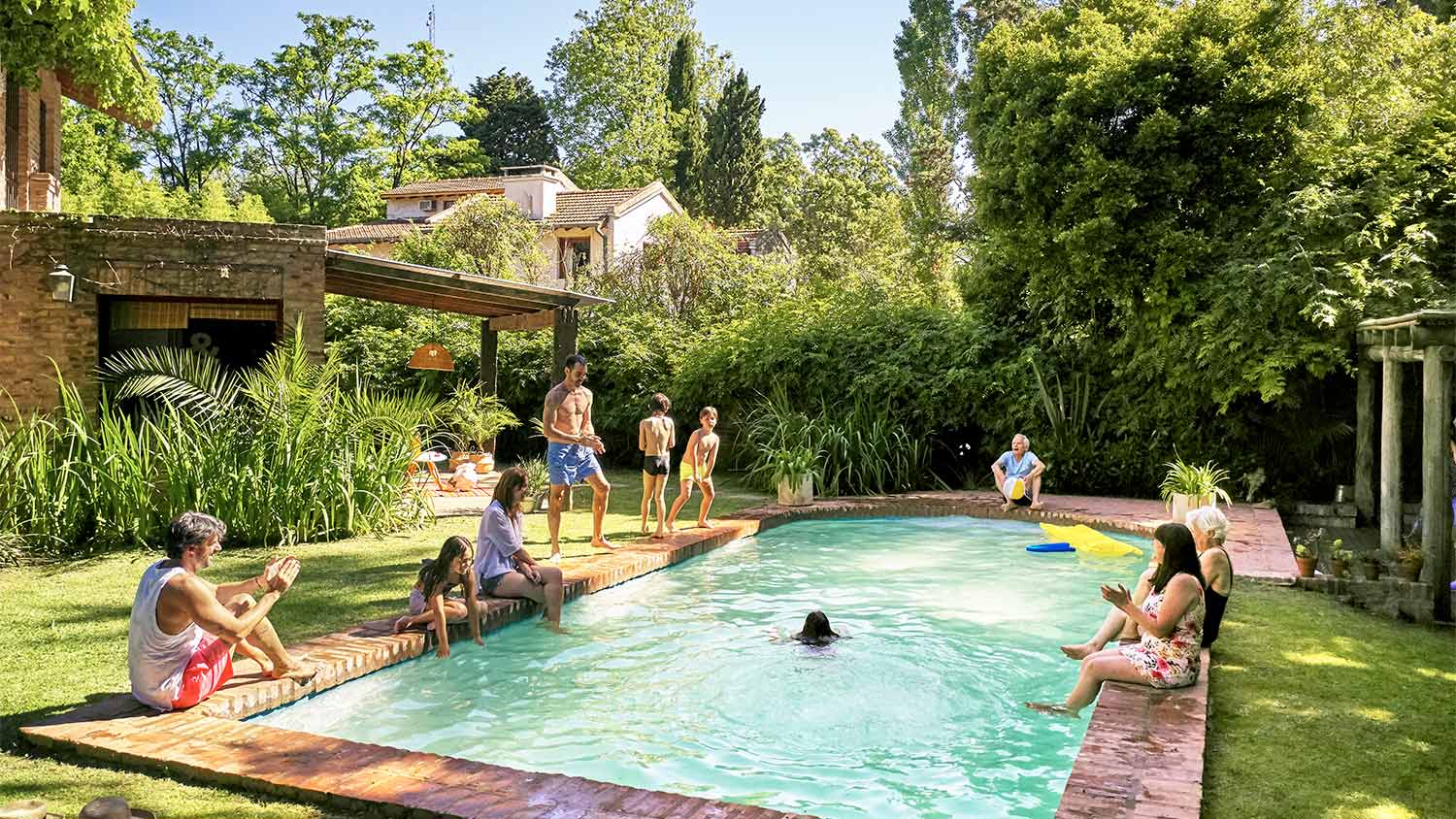 A family plays by a swimming pool