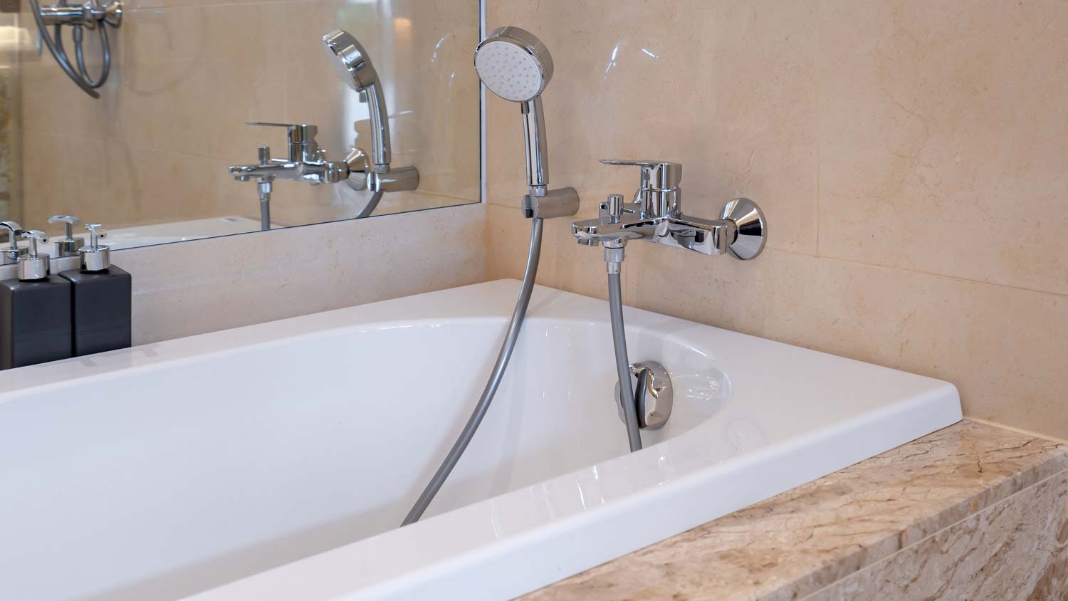 A white fiberglass bathtub with a shower head