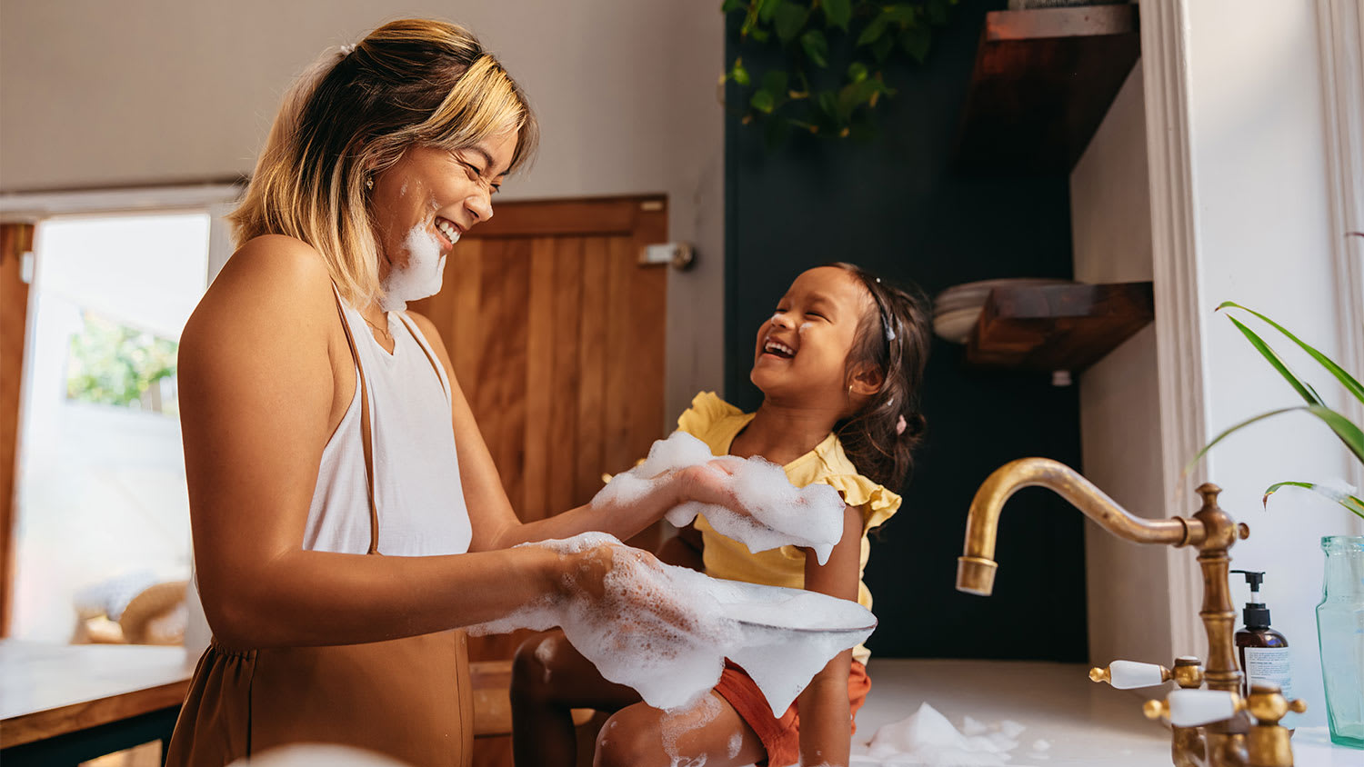 A mother and daughter wash dishes