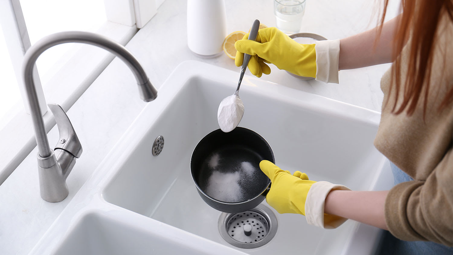 A woman sprinkles baking soda on a pot
