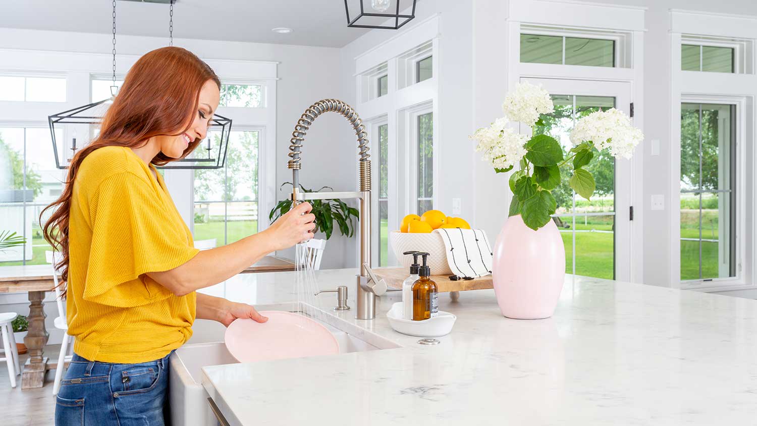 Woman washing dishes in a farmhouse style kitchen