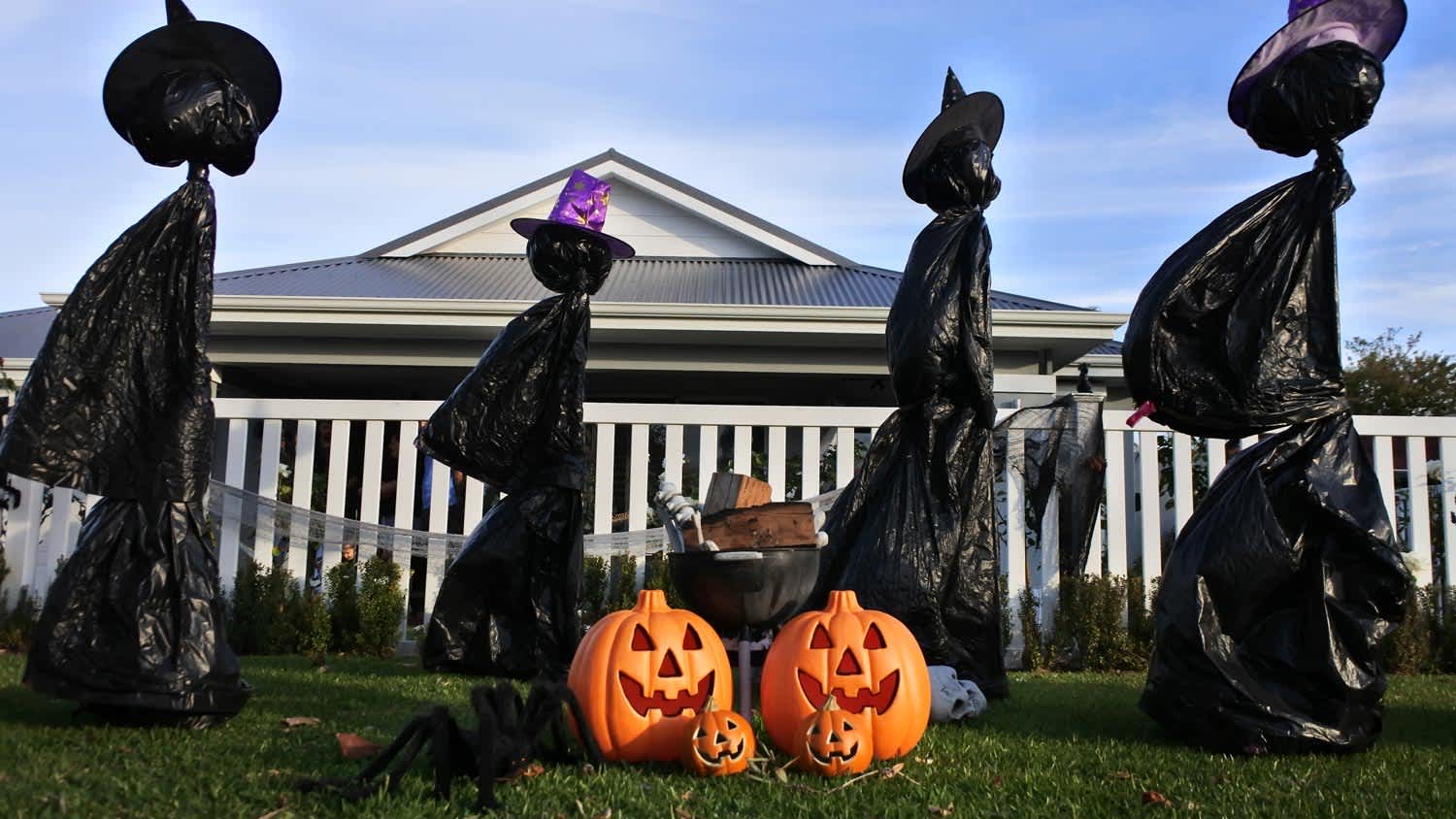 DIY Halloween witches in the front yard of a house