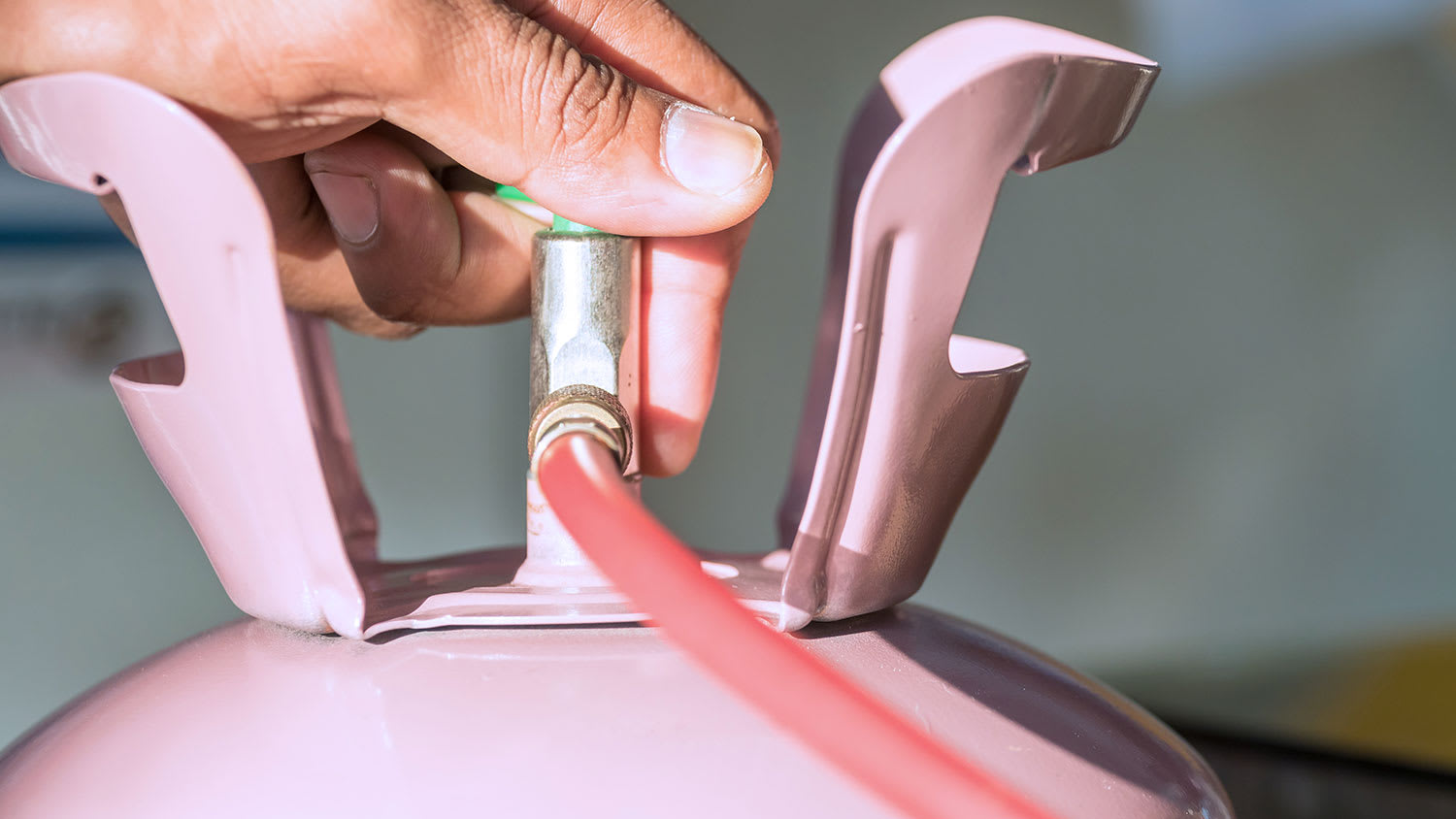 A closeup of a pink tank of refrigerant