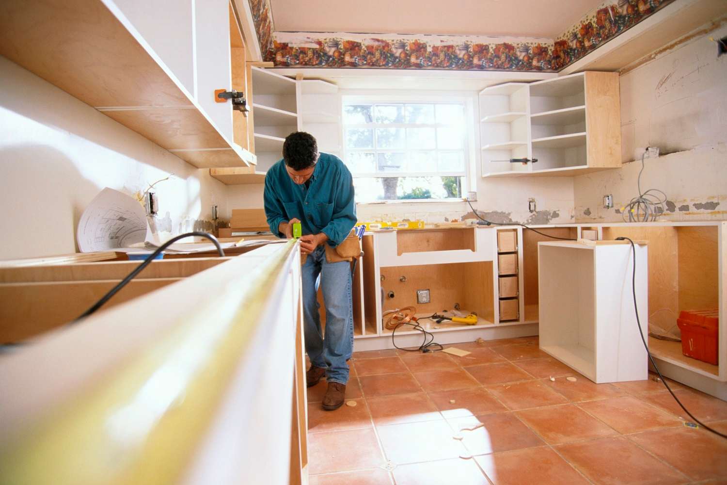 A modern kitchen with white cabinets and wooden countertop