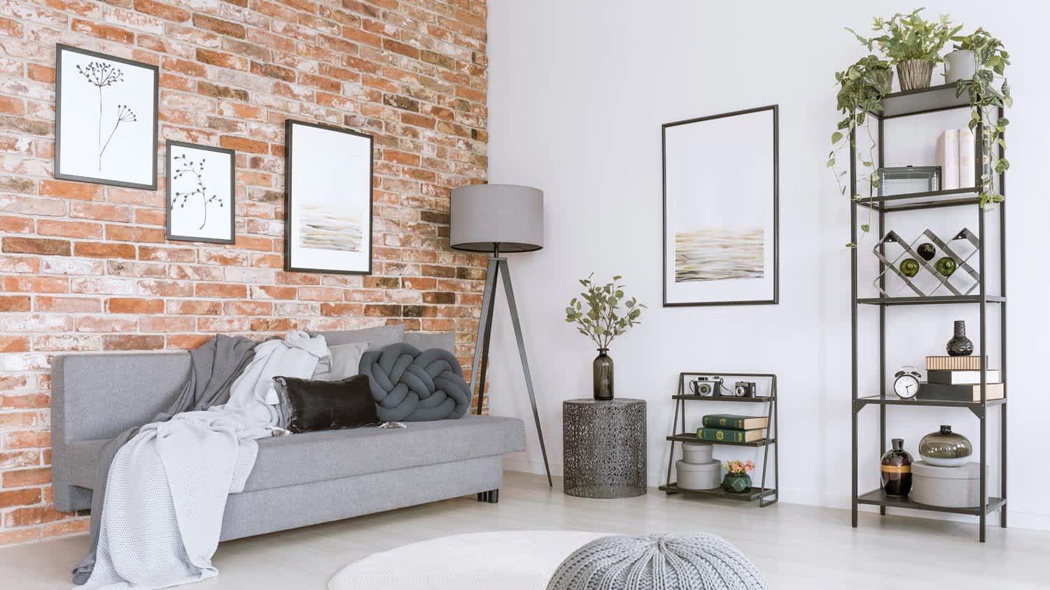 A white and gray living room with an exposed brick wall