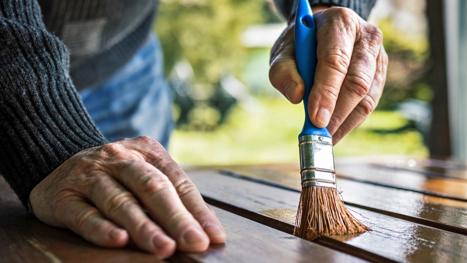 Senior man painting wooden table
