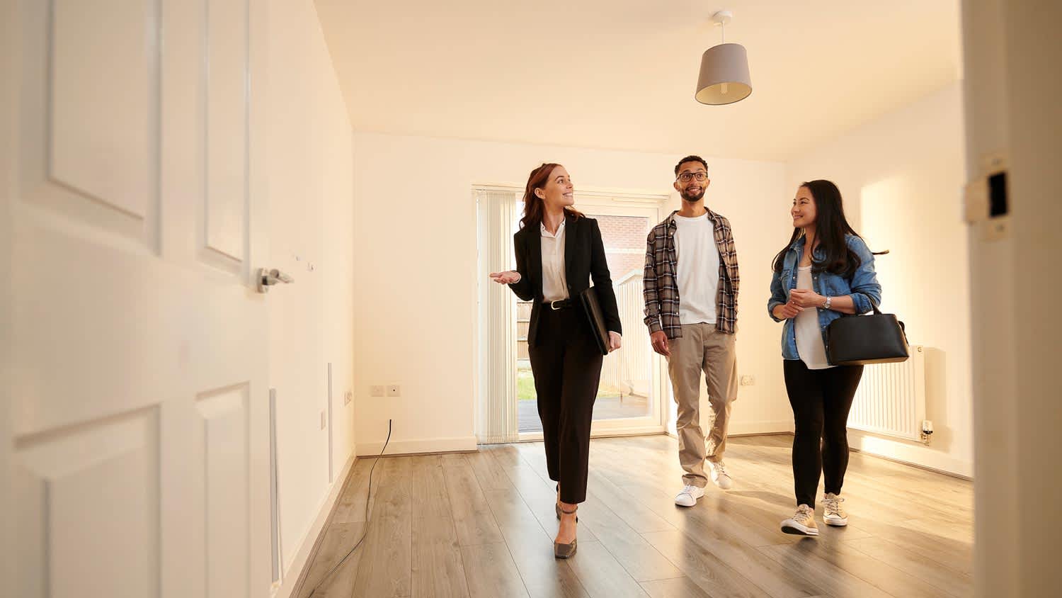 A real estate agent showing a house to a couple