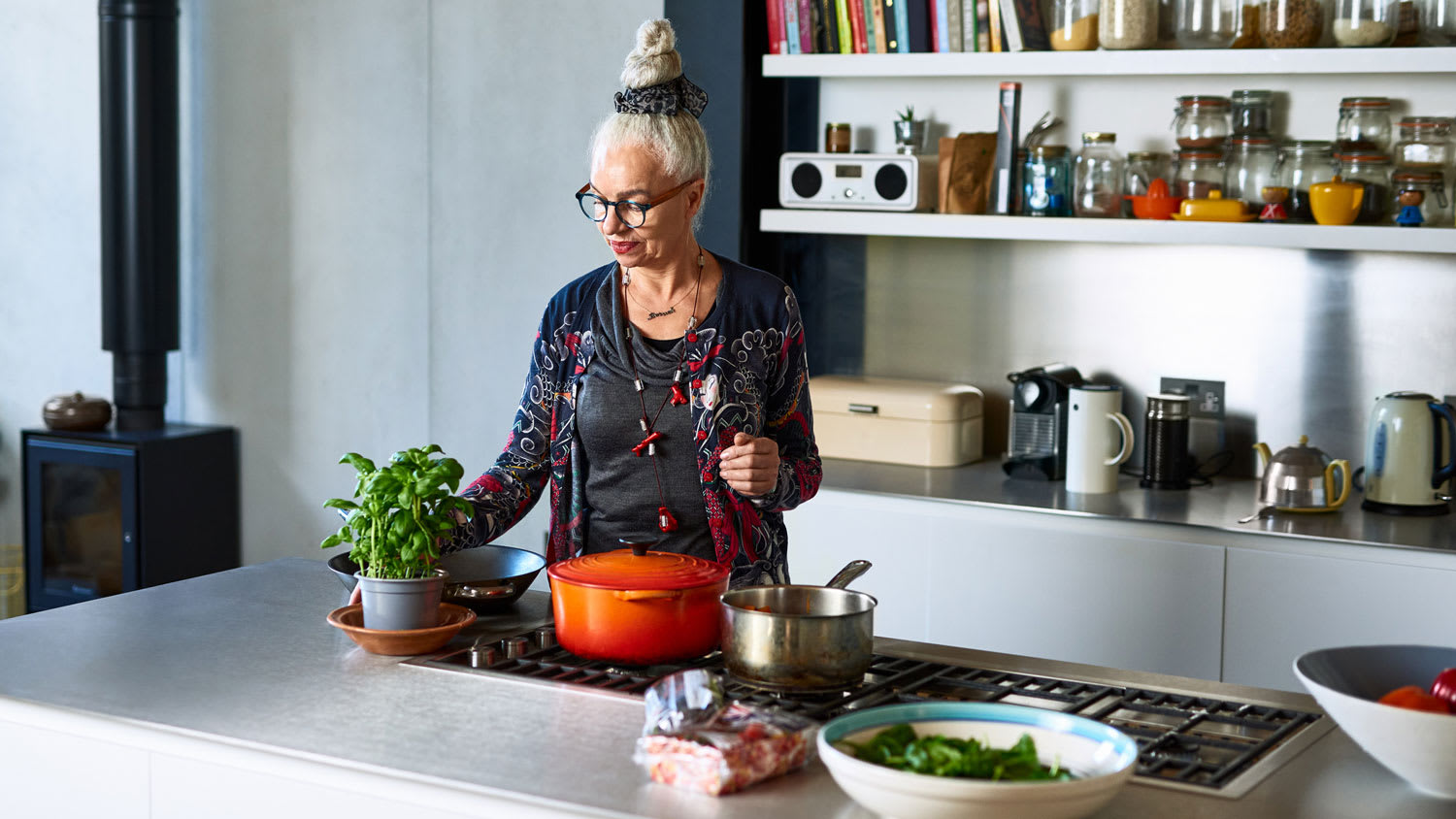 A senior woman preparing dinner in her stylish kitchen