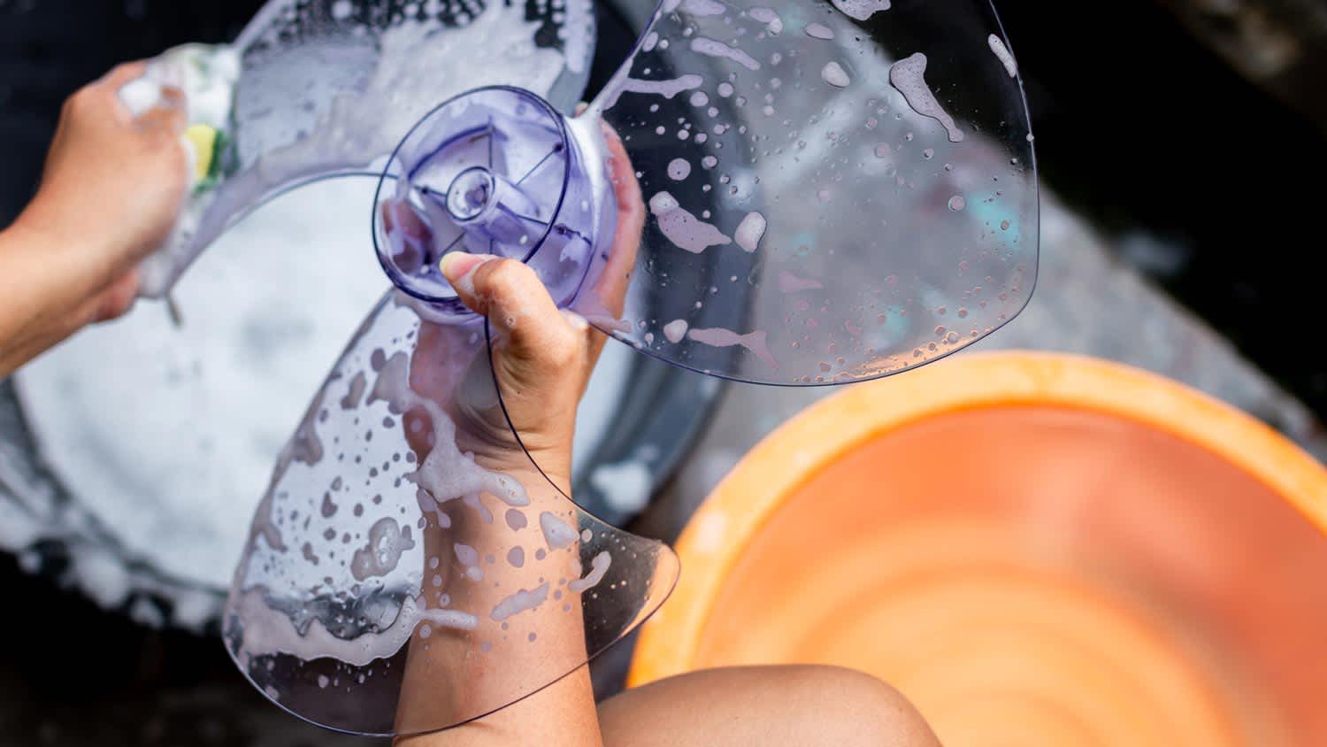 A woman cleaning a fan