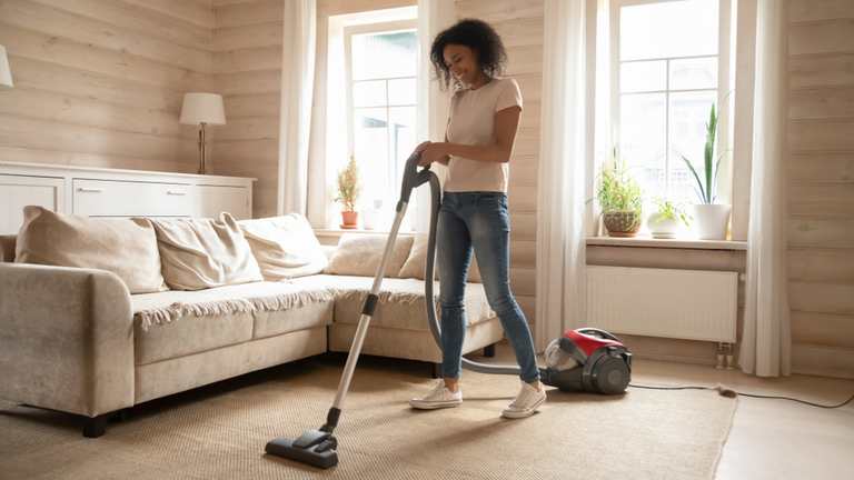 Woman vacuuming floor in living room