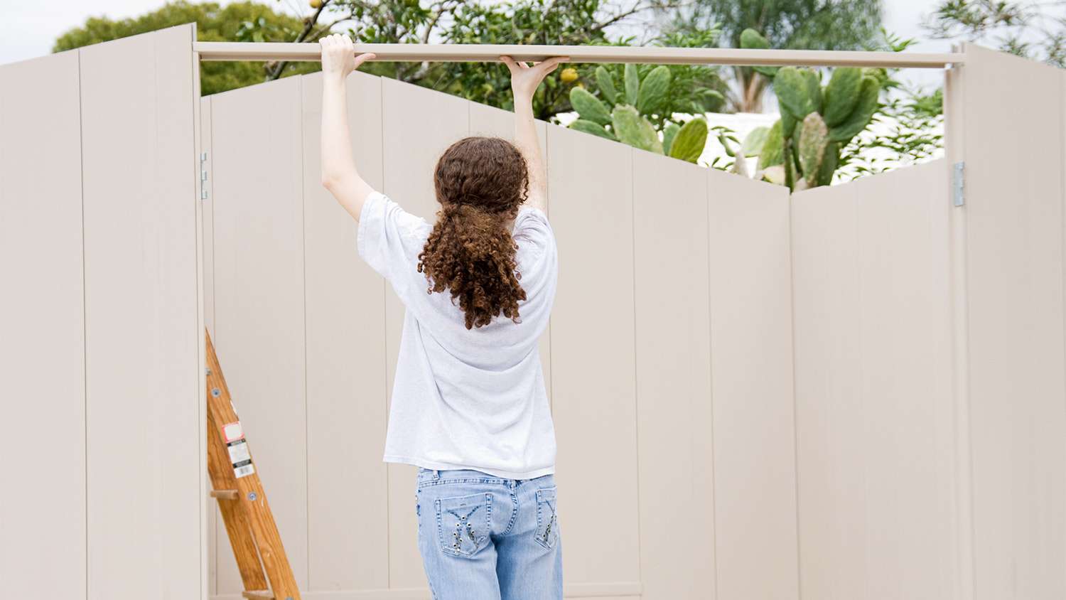 Young woman putting roof on shed.