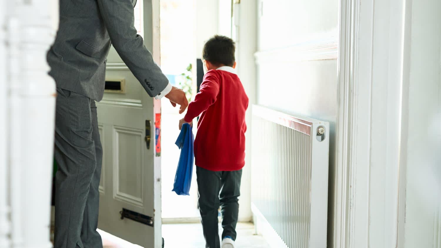 Boy leaving house with book bag