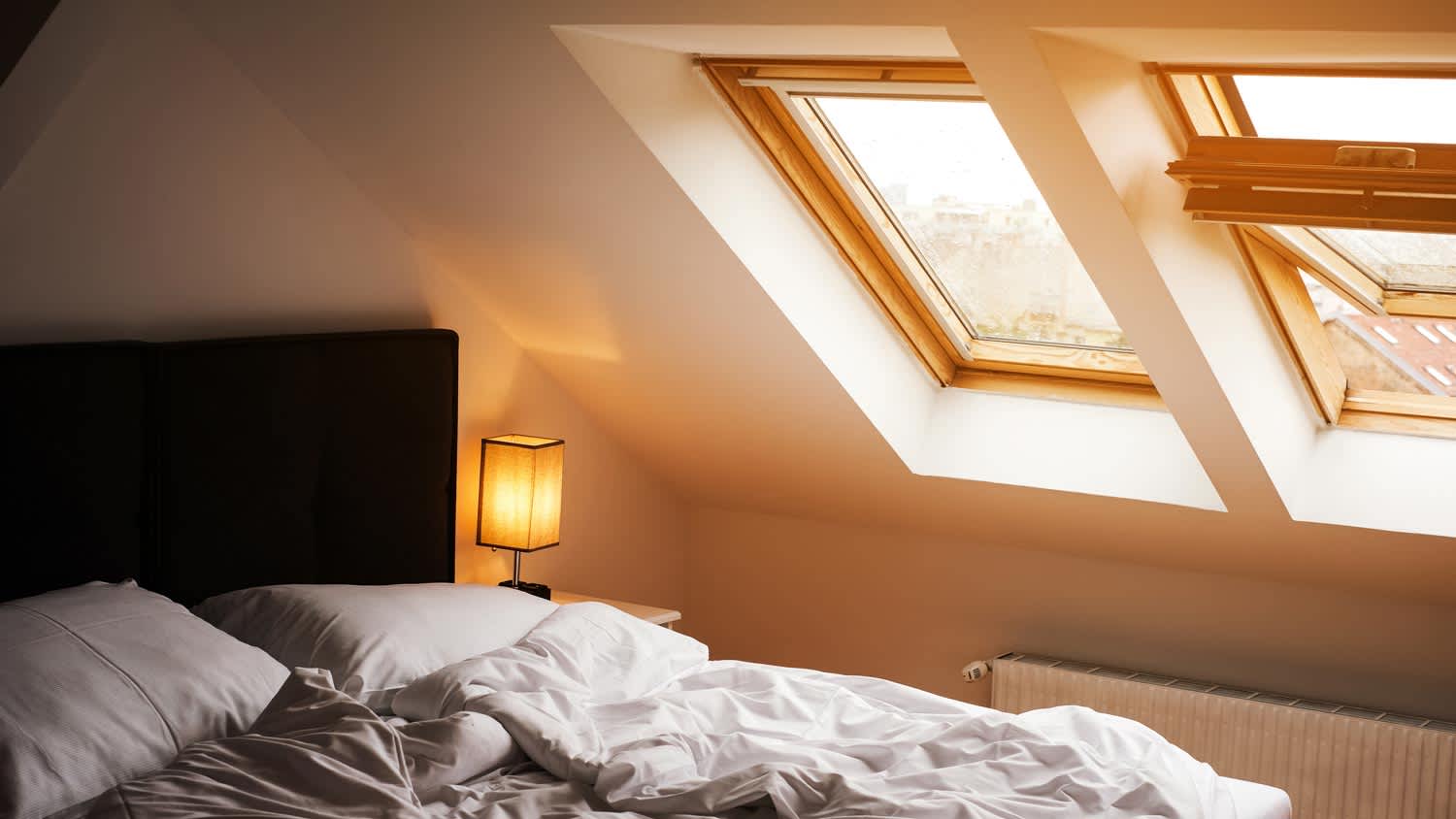 A cozy bedroom with a white bed and skylights