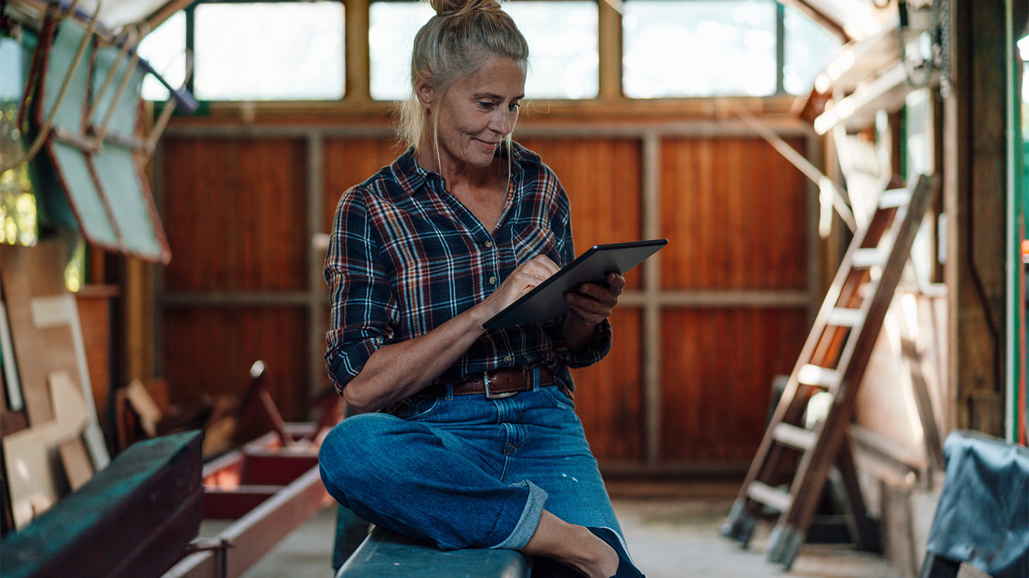 Woman planning on ipad in the garage.