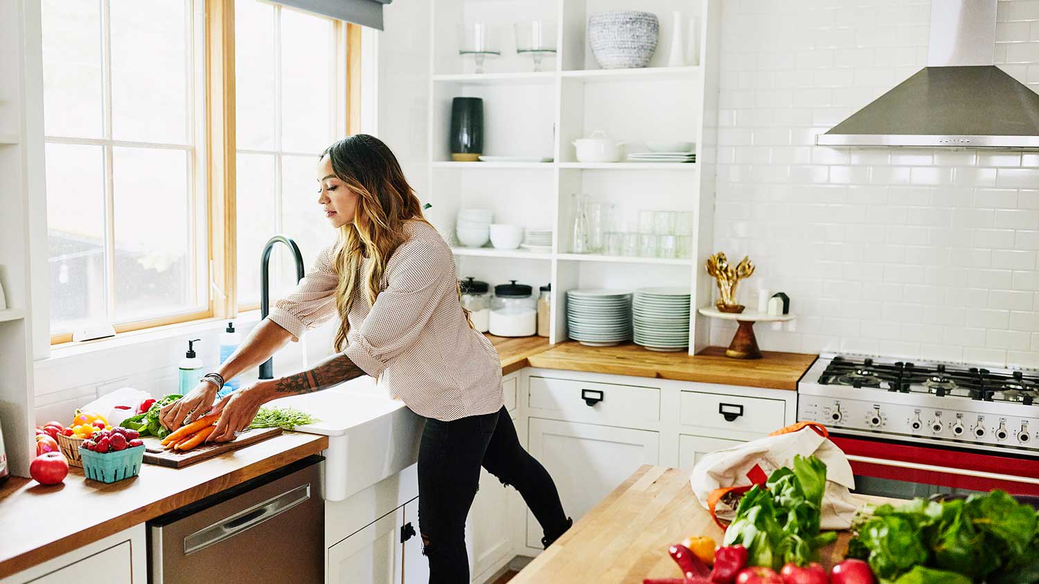 Woman in her kitchen washing fresh vegetables