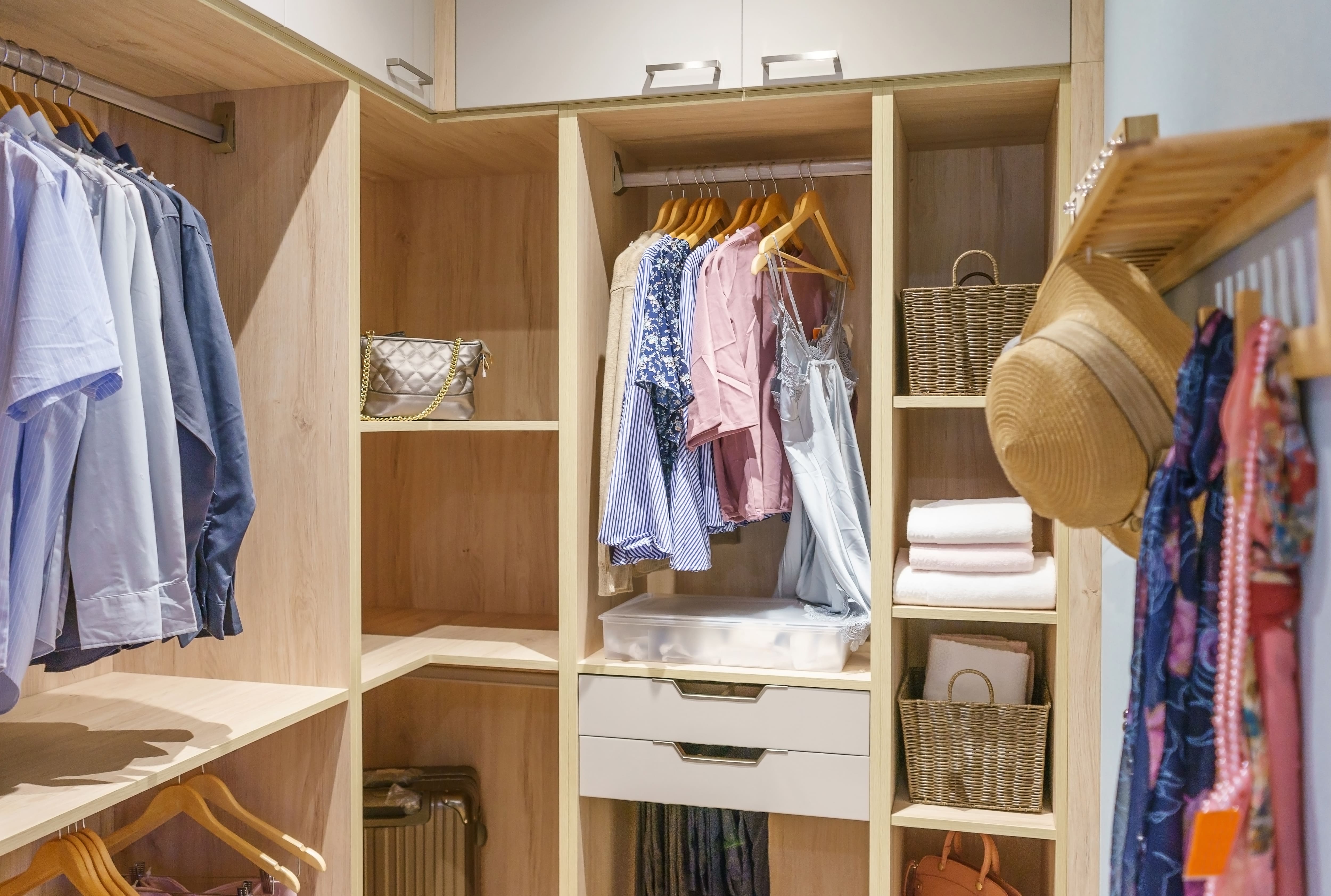 An organized closet with wicker bins and a hanging rack