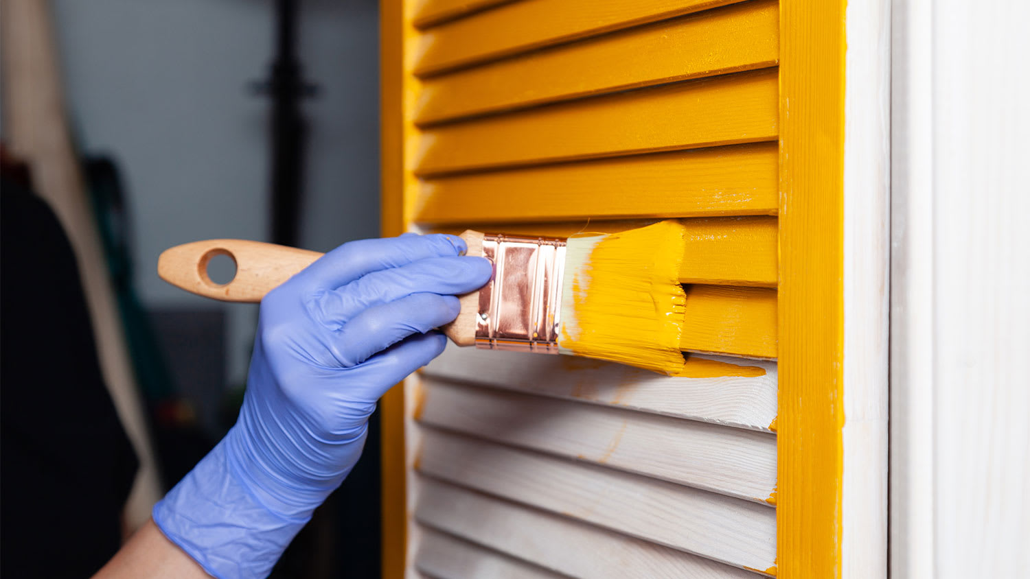 A view of shutters being painted yellow