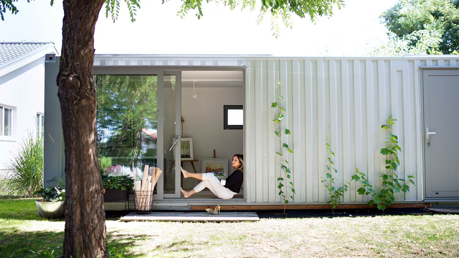 A woman sits in a modified shipping container