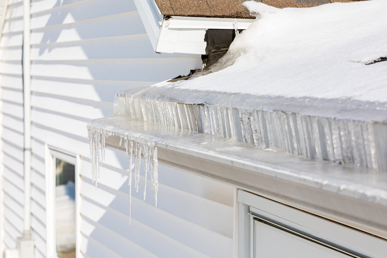 A roof gutter filled with icicles
