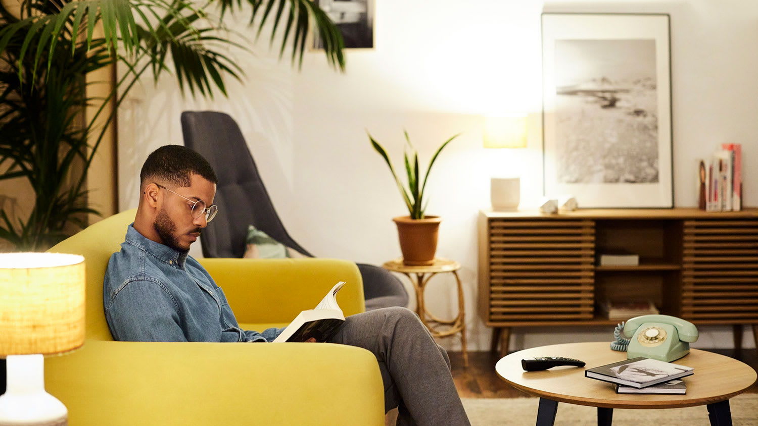 Relaxed man reading a book in the living room