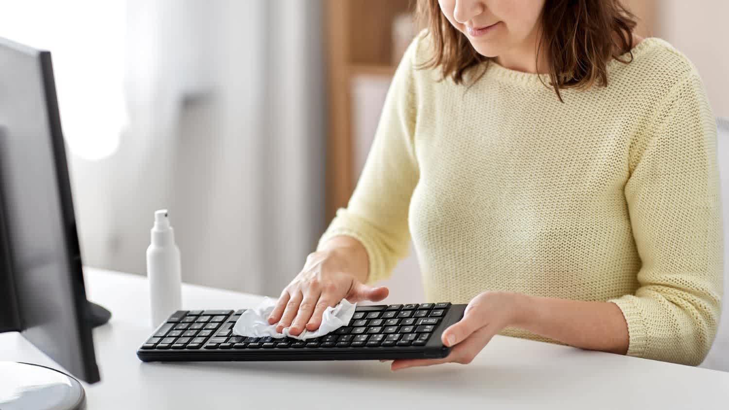 A woman cleaning a keyboard