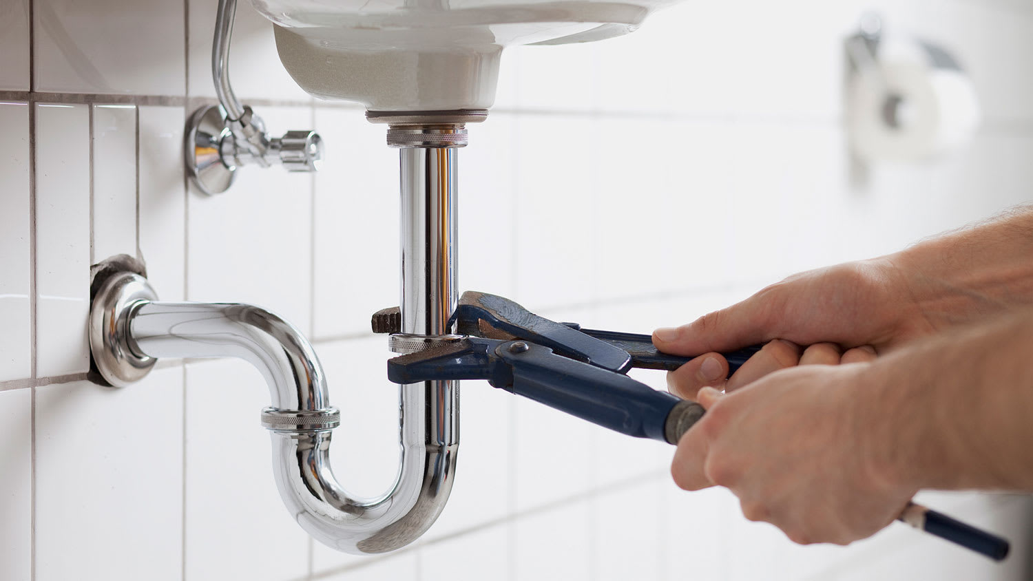 Plumber removing bathroom sink p trap