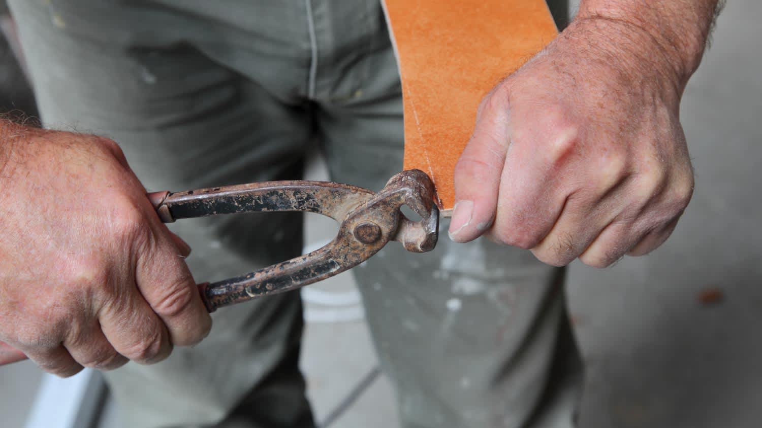 A worker cutting tile using tile nippers