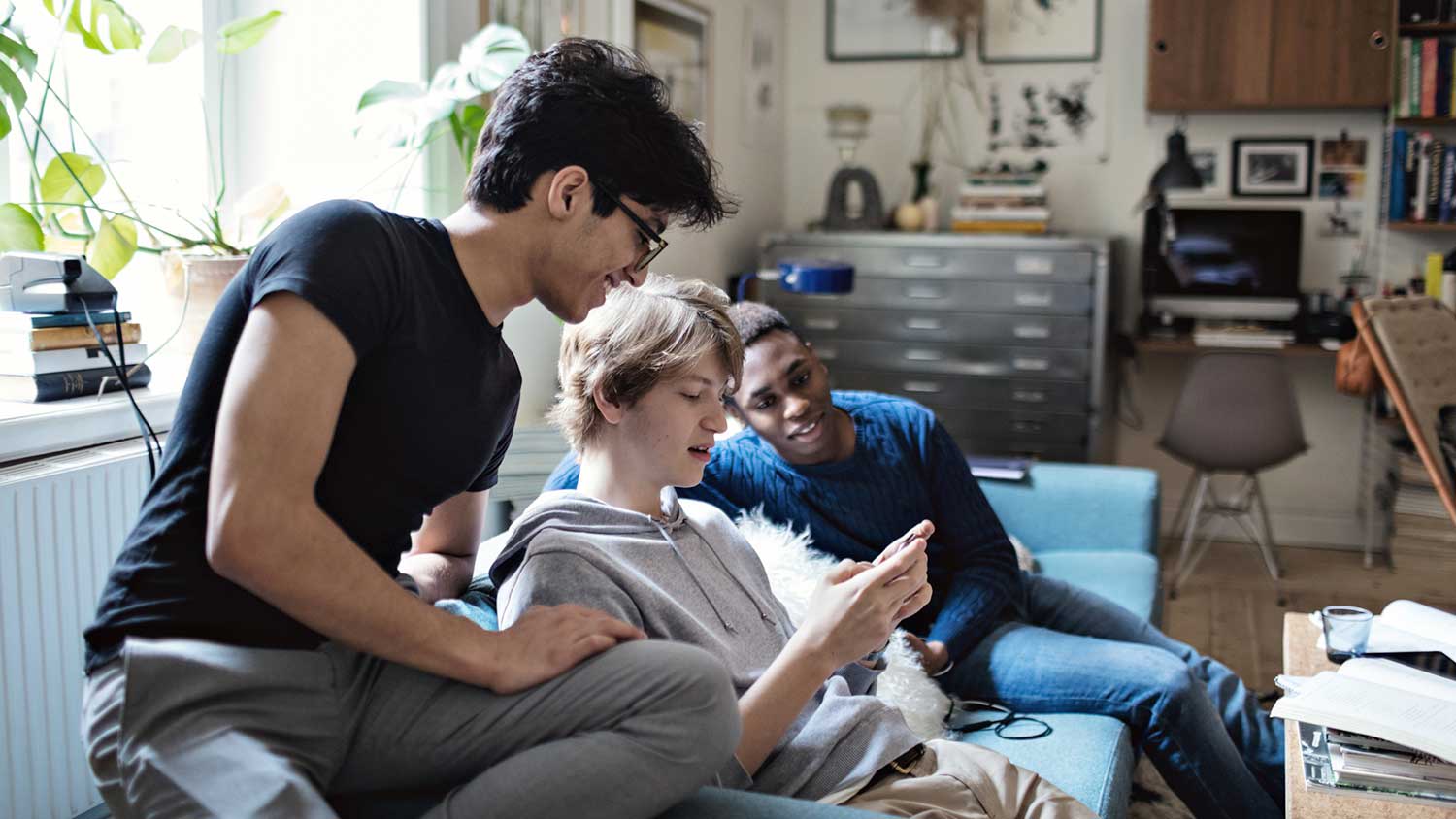 Teenager boys sitting on a couch using their phone