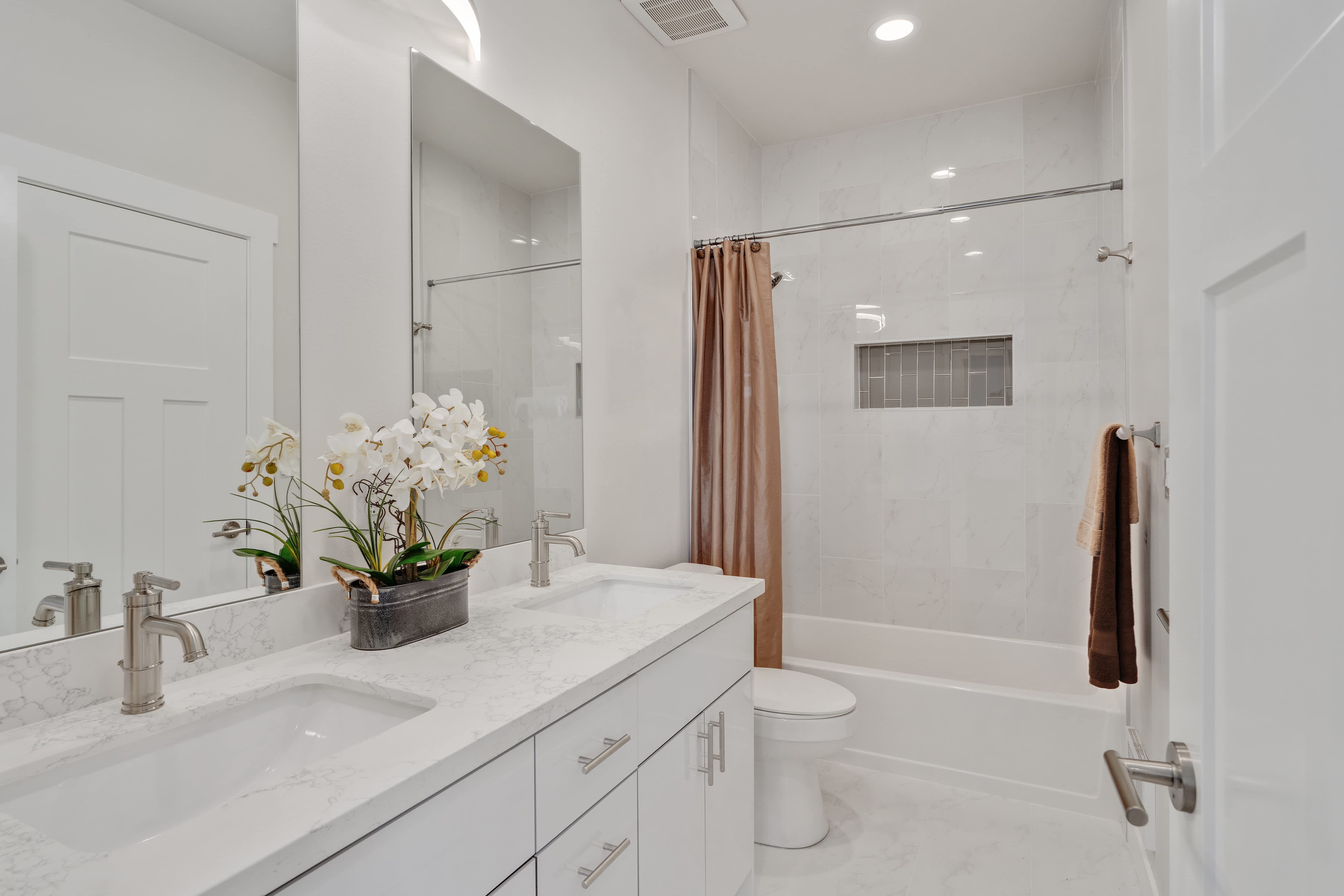 All-white bathroom with brushed aluminum hardware