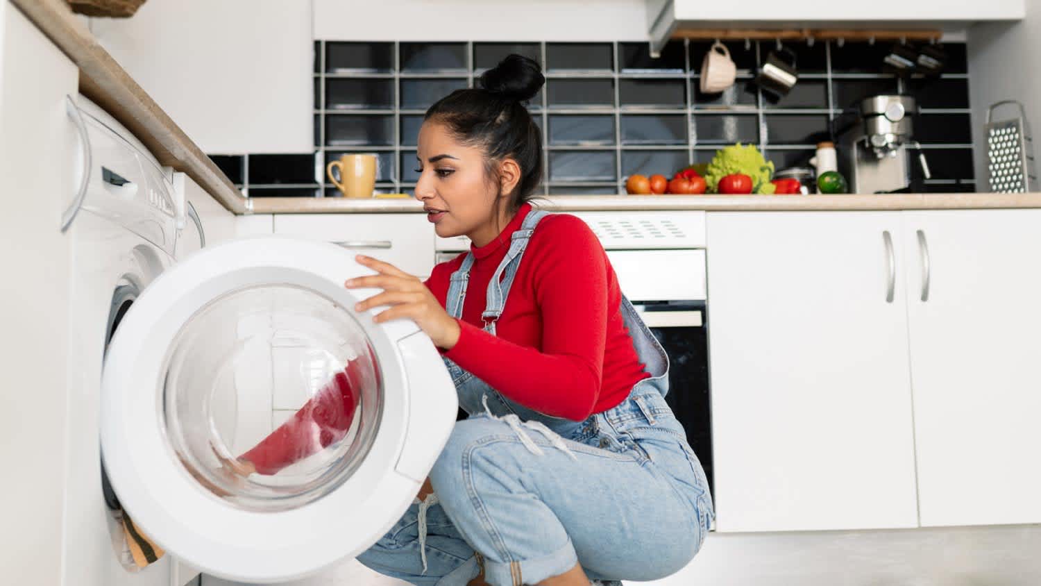A woman opening the door of the washing machine