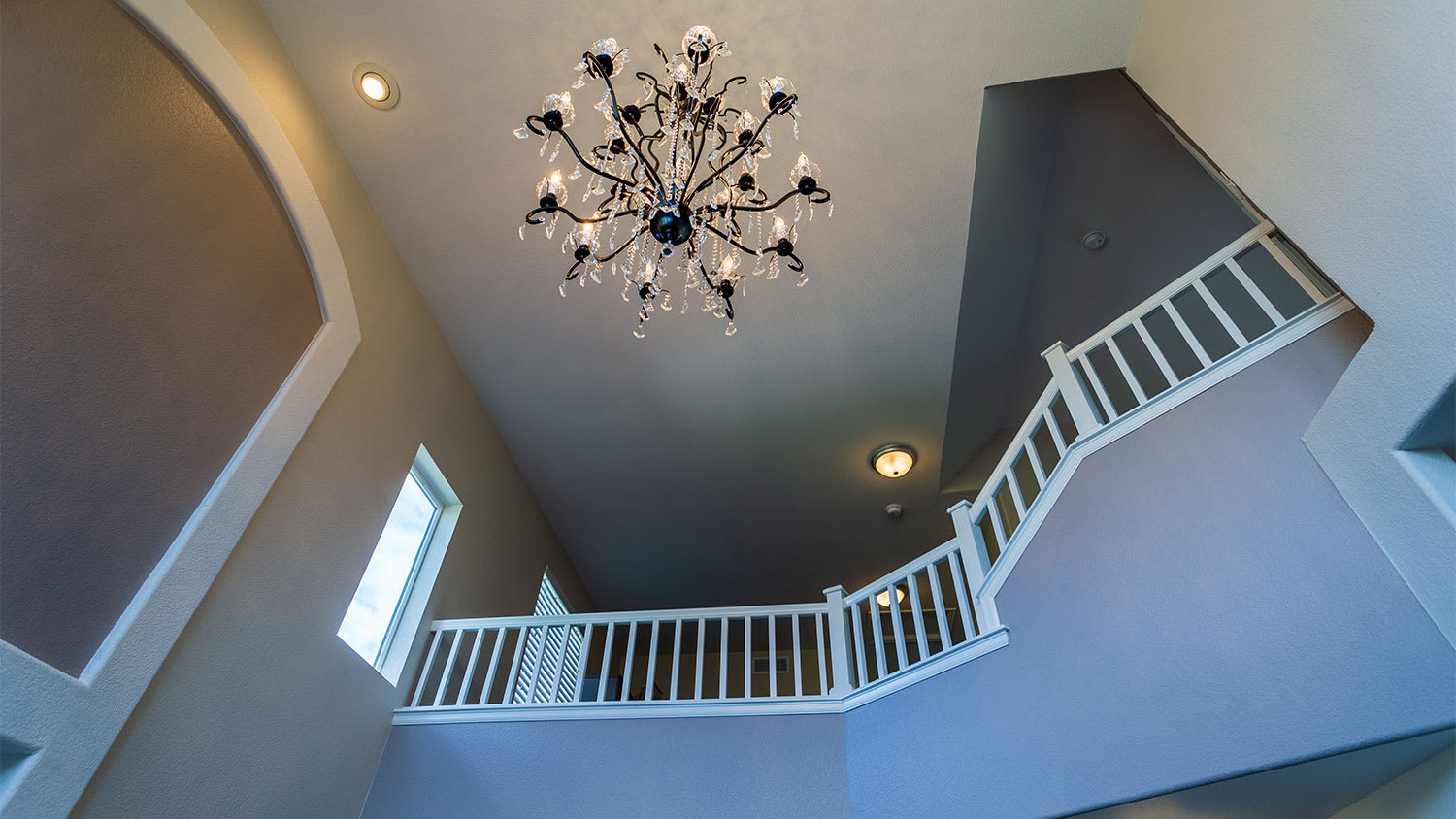 A view of a chandelier in a foyer from below