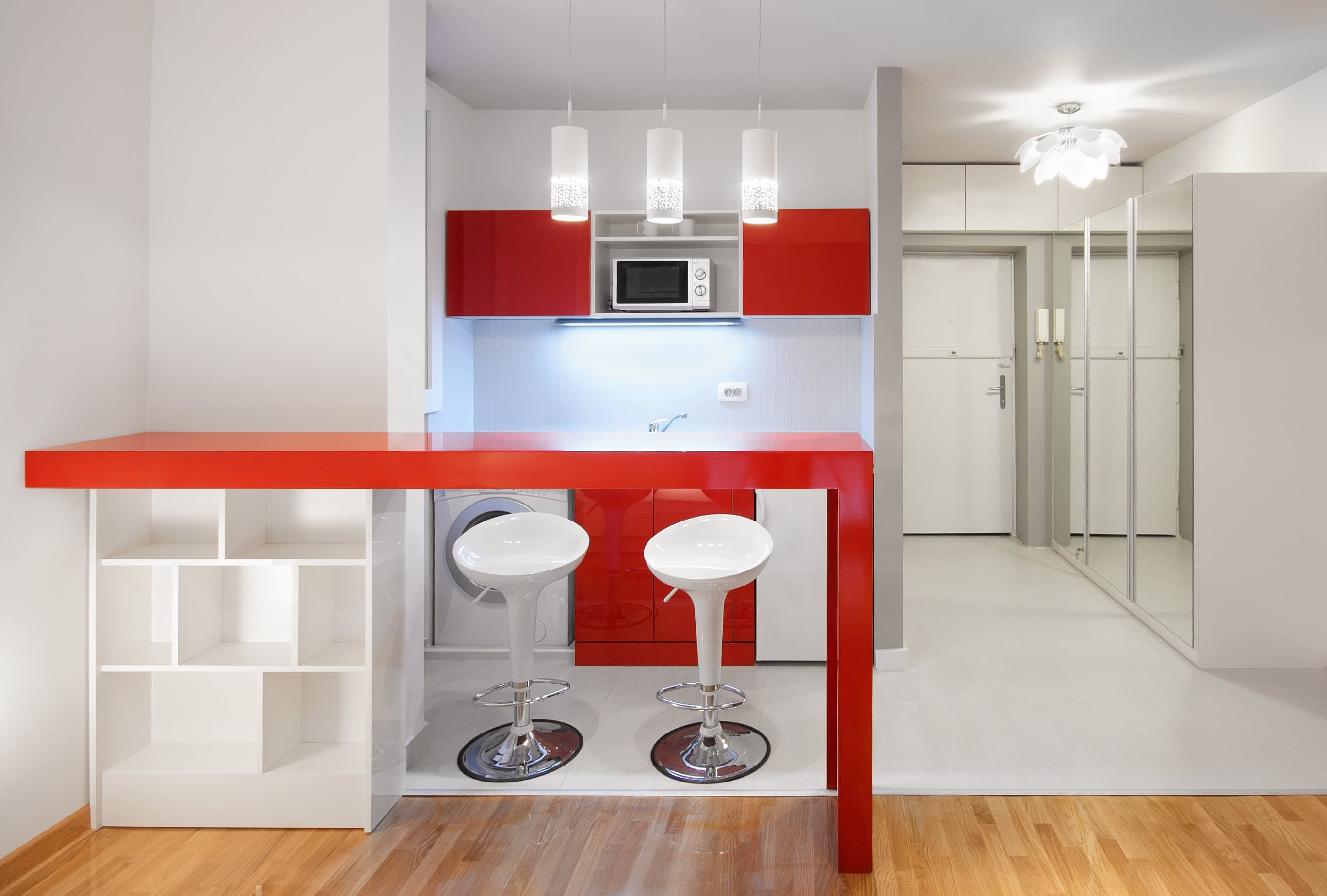 Bright red accent color in small kitchenette area