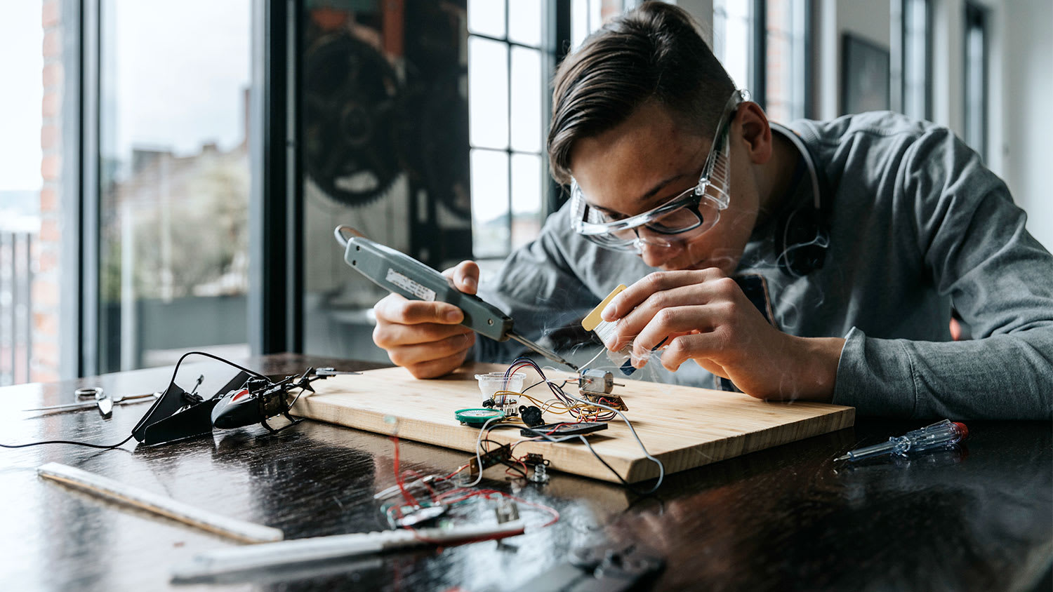 A man solders wires together