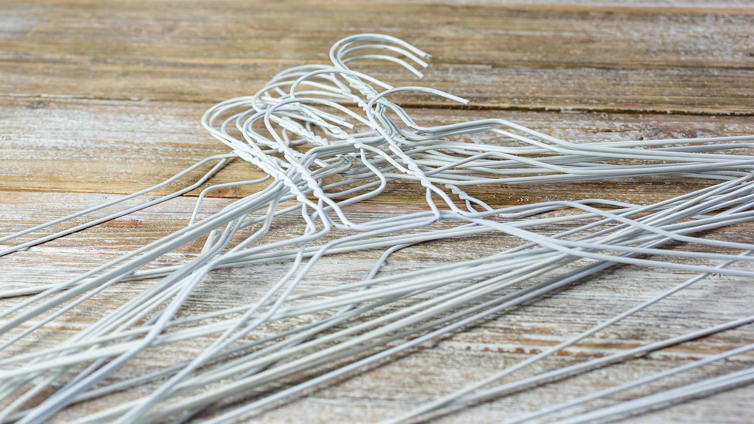 Pile of metal coat hangers on a table