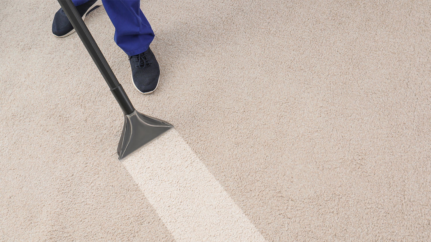 man cleaning carpet with professional vacuum cleaner