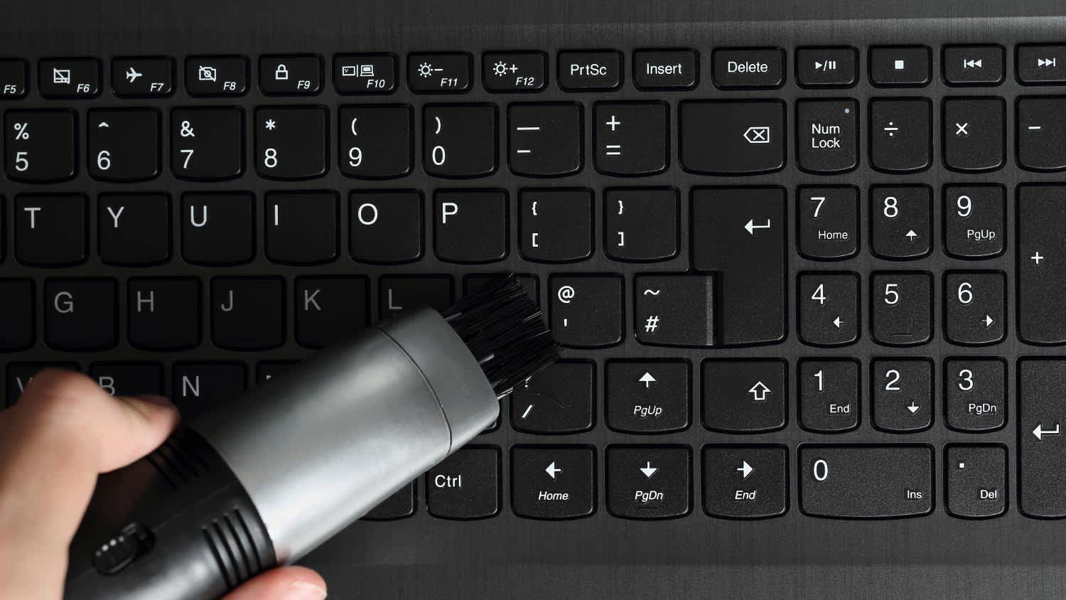 A man cleaning a black keyboard