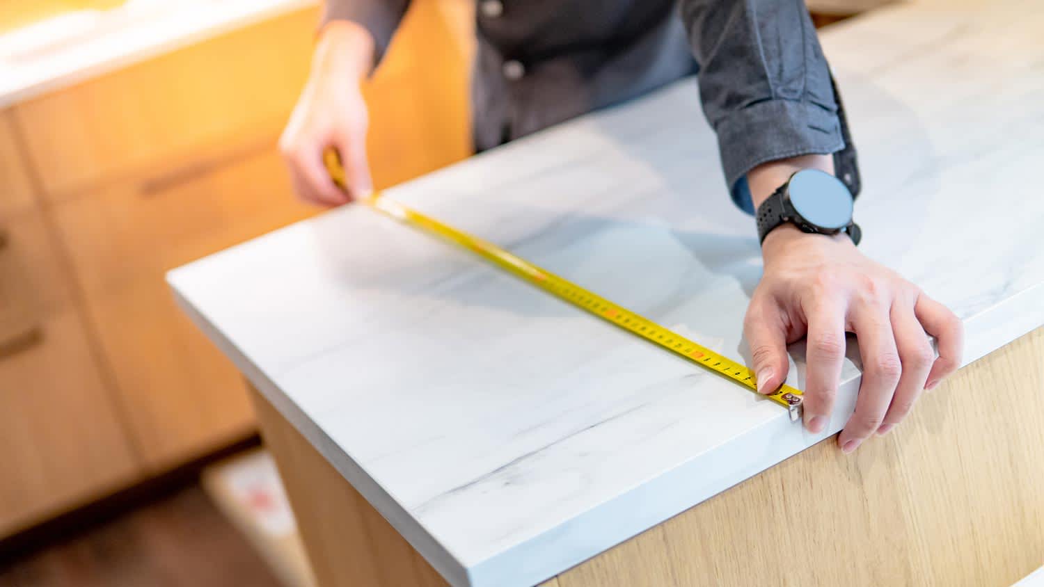A man measuring a countertop