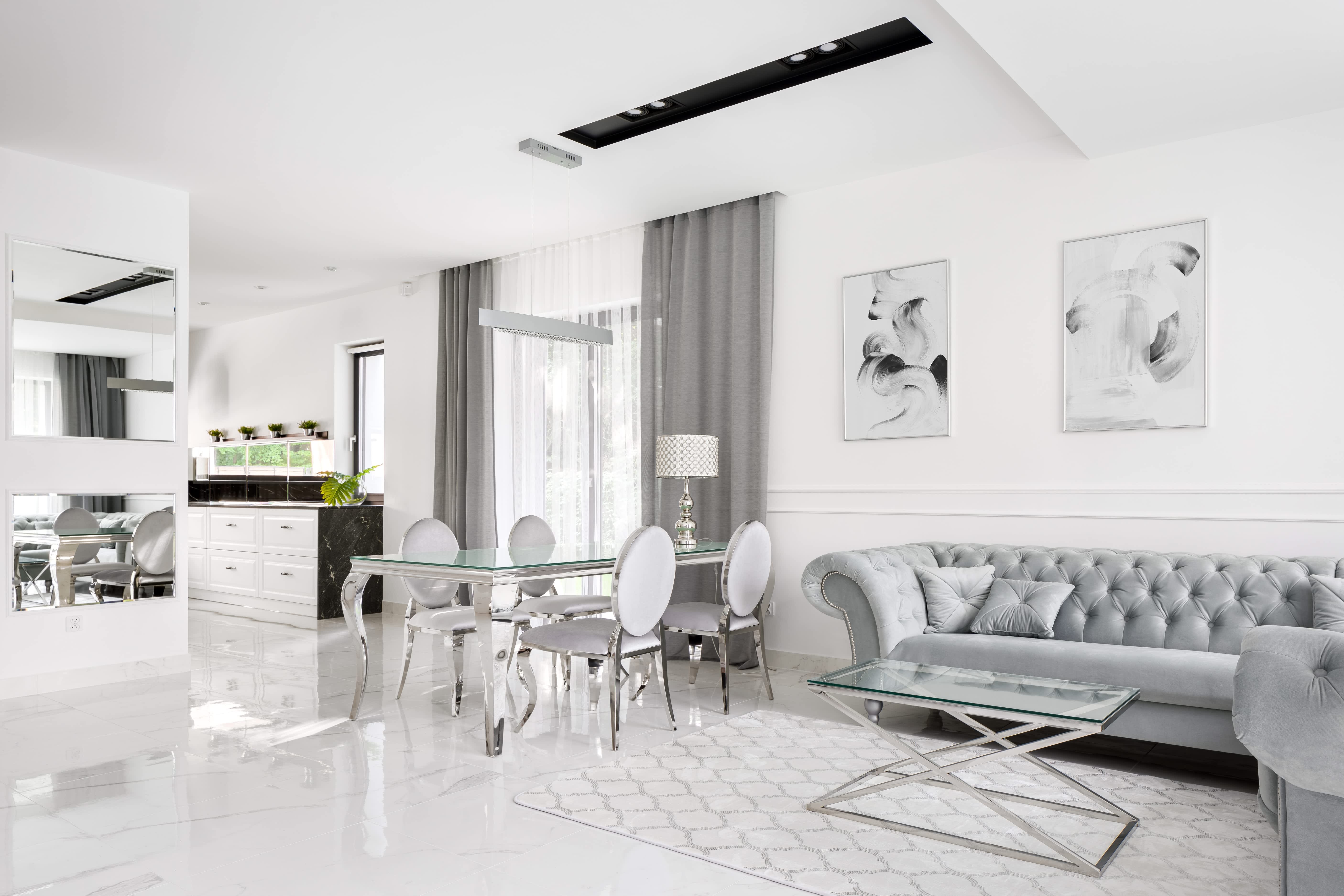 A gray and white living room with a dining table