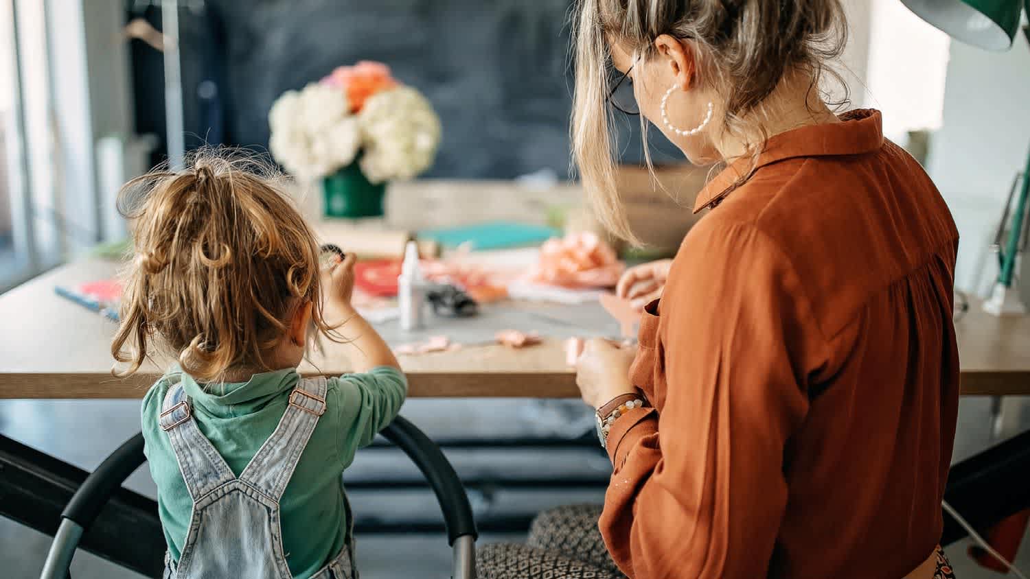 Mother and daughter making flowers of paper