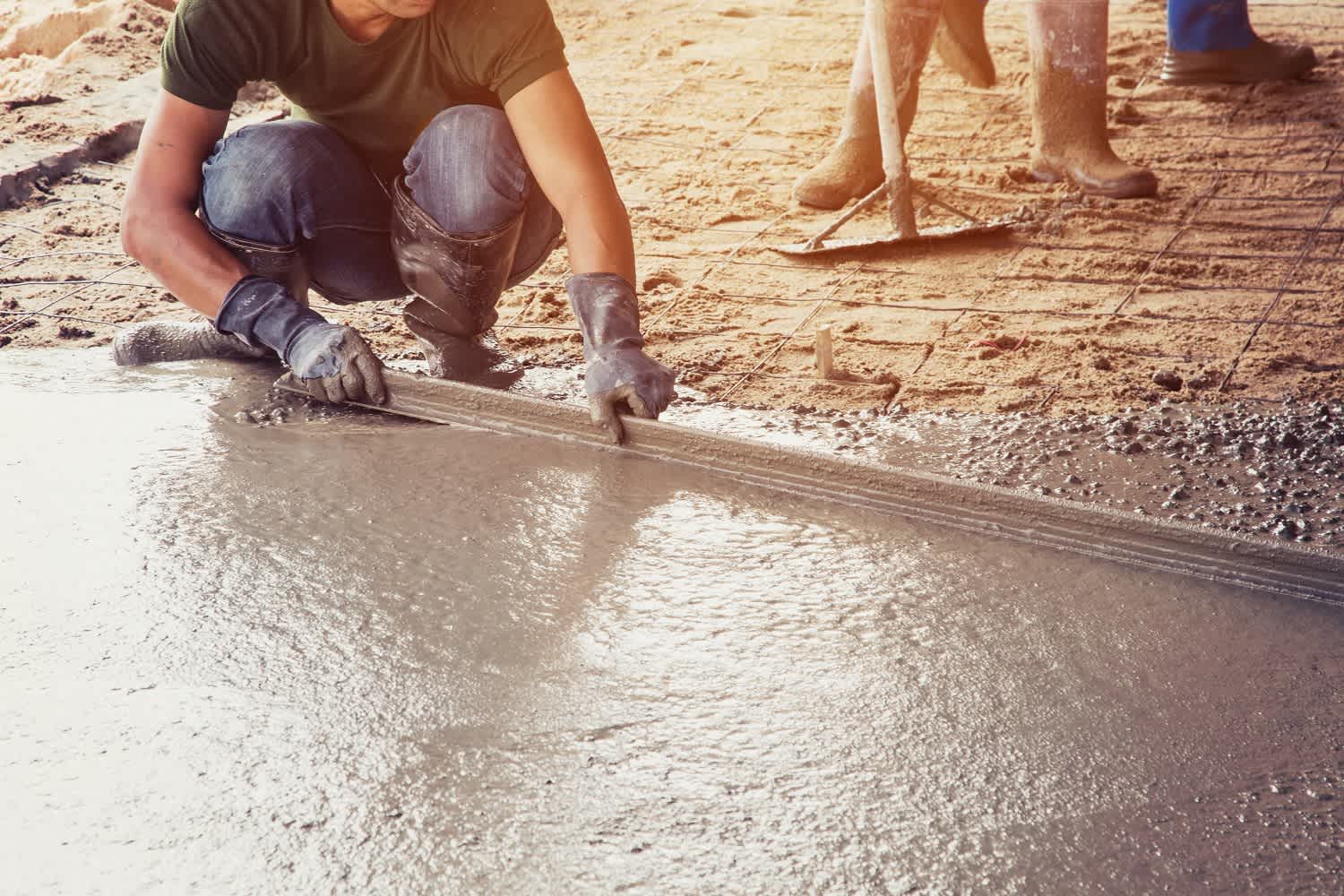 Man spreading concrete for a floor