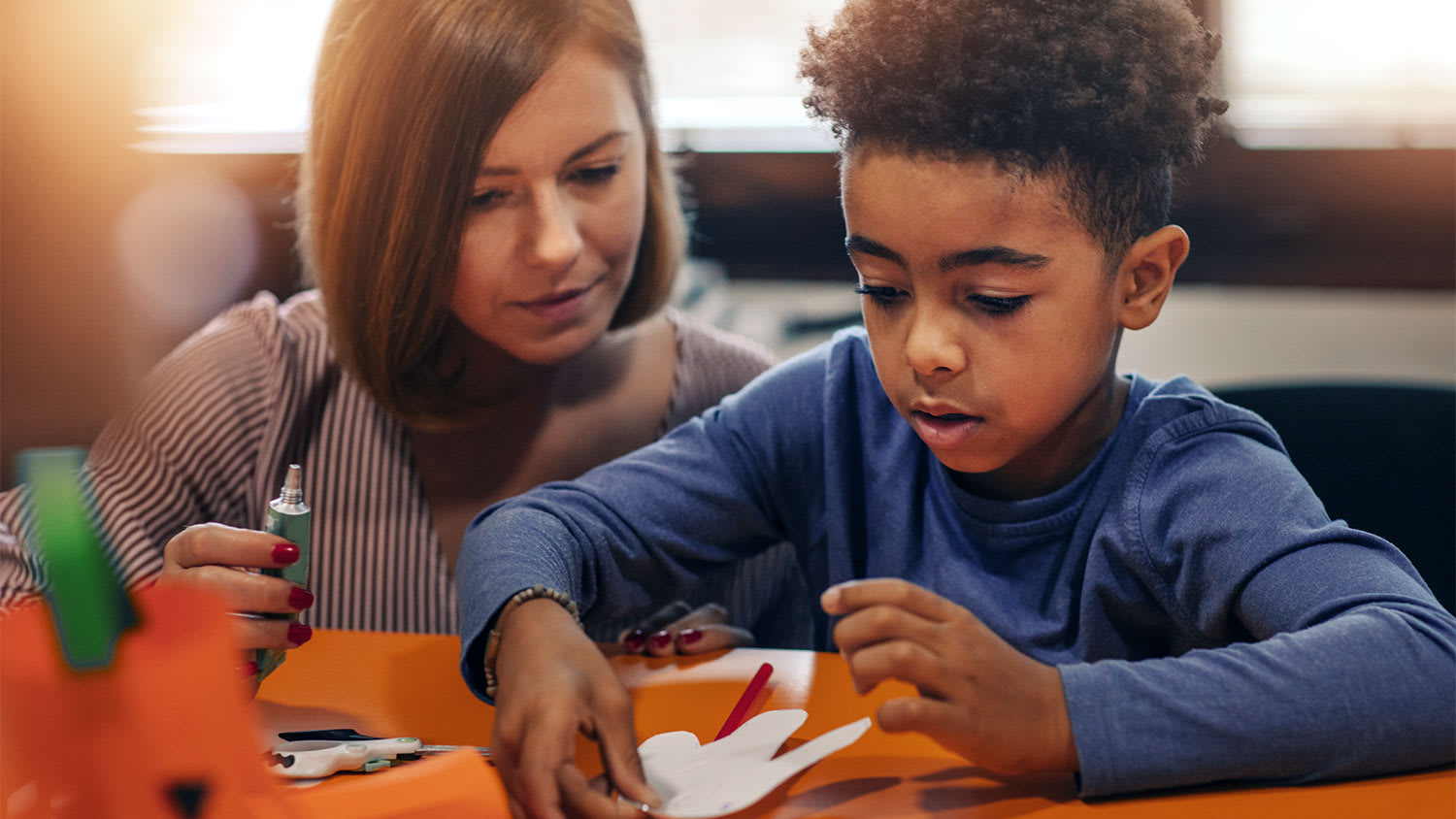 A mother and son make crafts with superglue