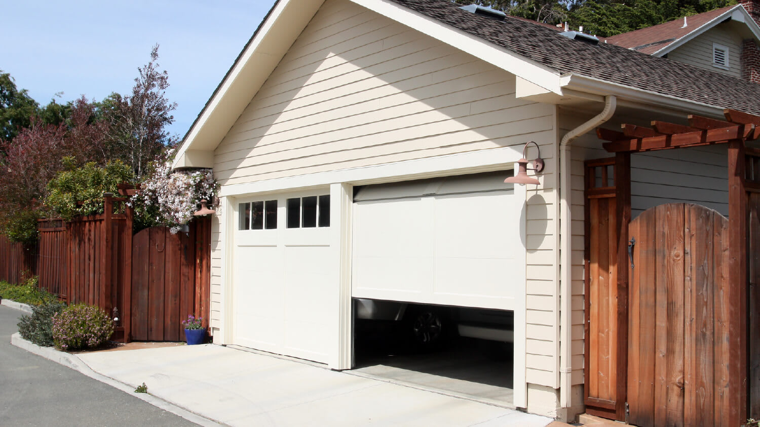 white sectional garage door half open with car inside