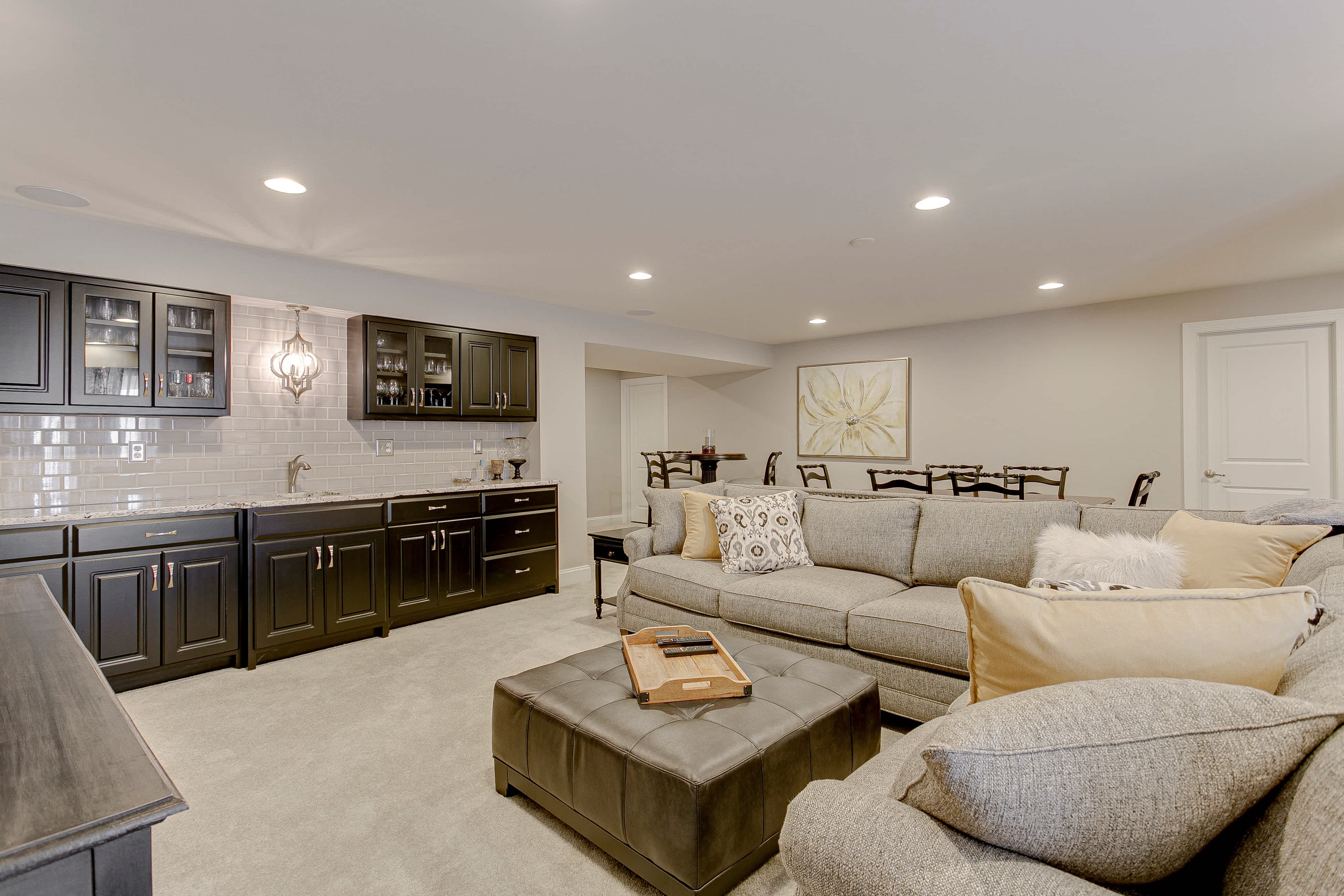 A large living room with a wet bar featuring a subway tile backsplash